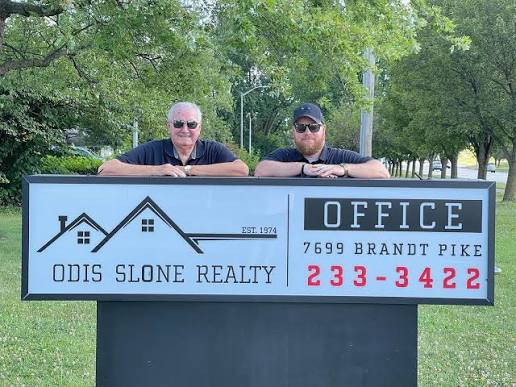 Odis Slone Jr. and his grandson Brad Slone behind the Odis Slone Realty office sign on Brandt Pike