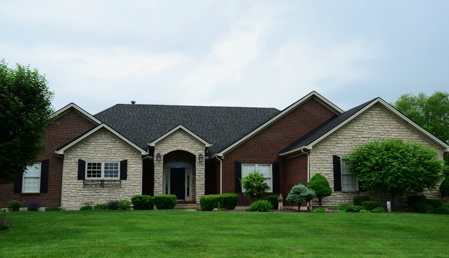 Brick ranch home with a green lawn and two-car garage