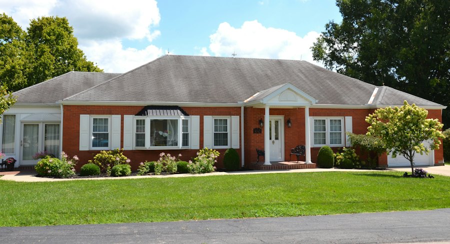 Small brick ranch home with a covered front stoop