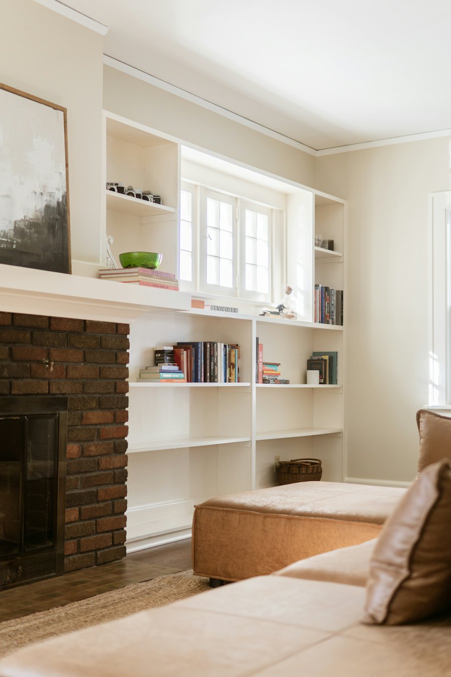 Living room with a brick fireplace and built-in bookshelves